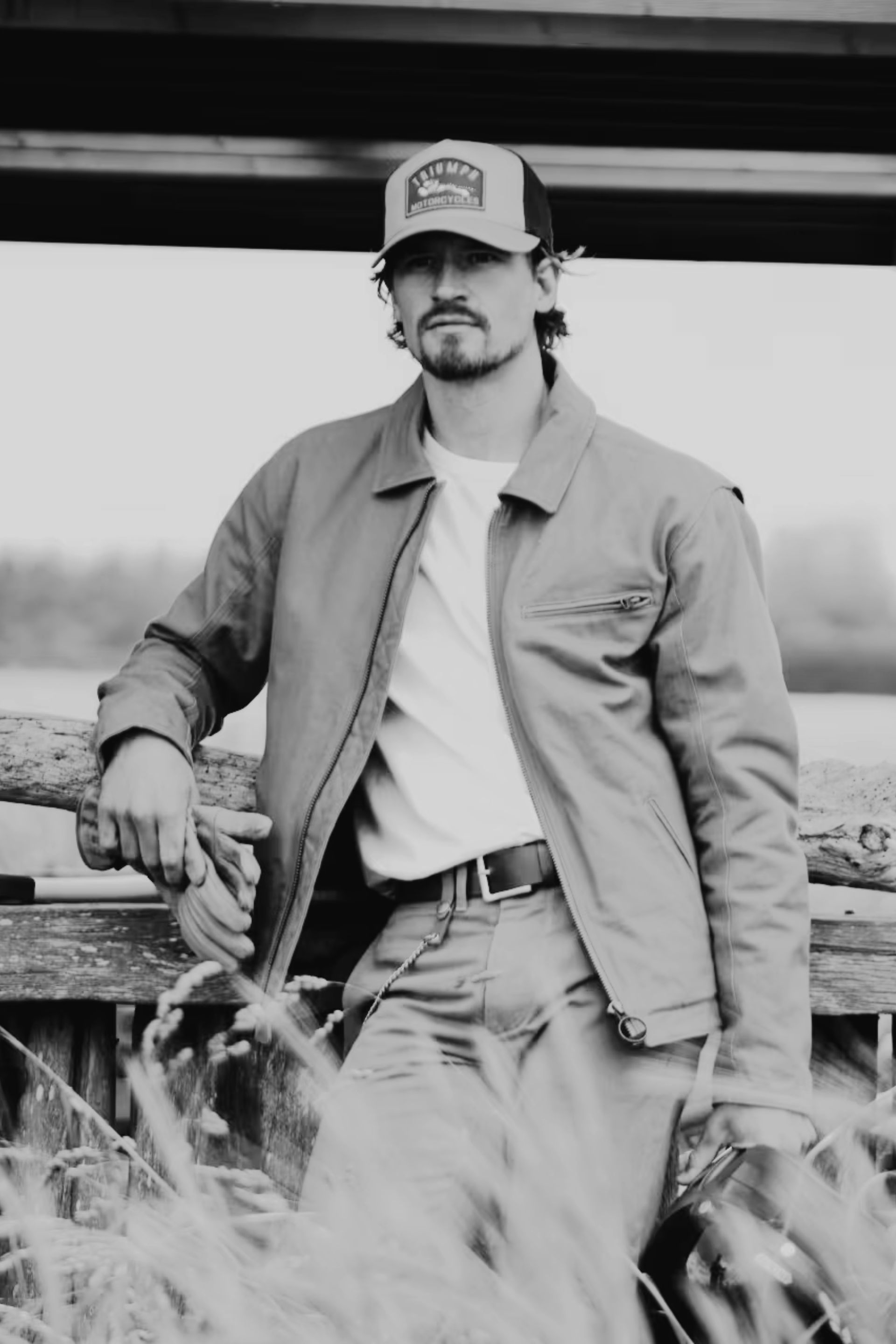 Man stood in field next to motorbike wearing Triumph Heritage