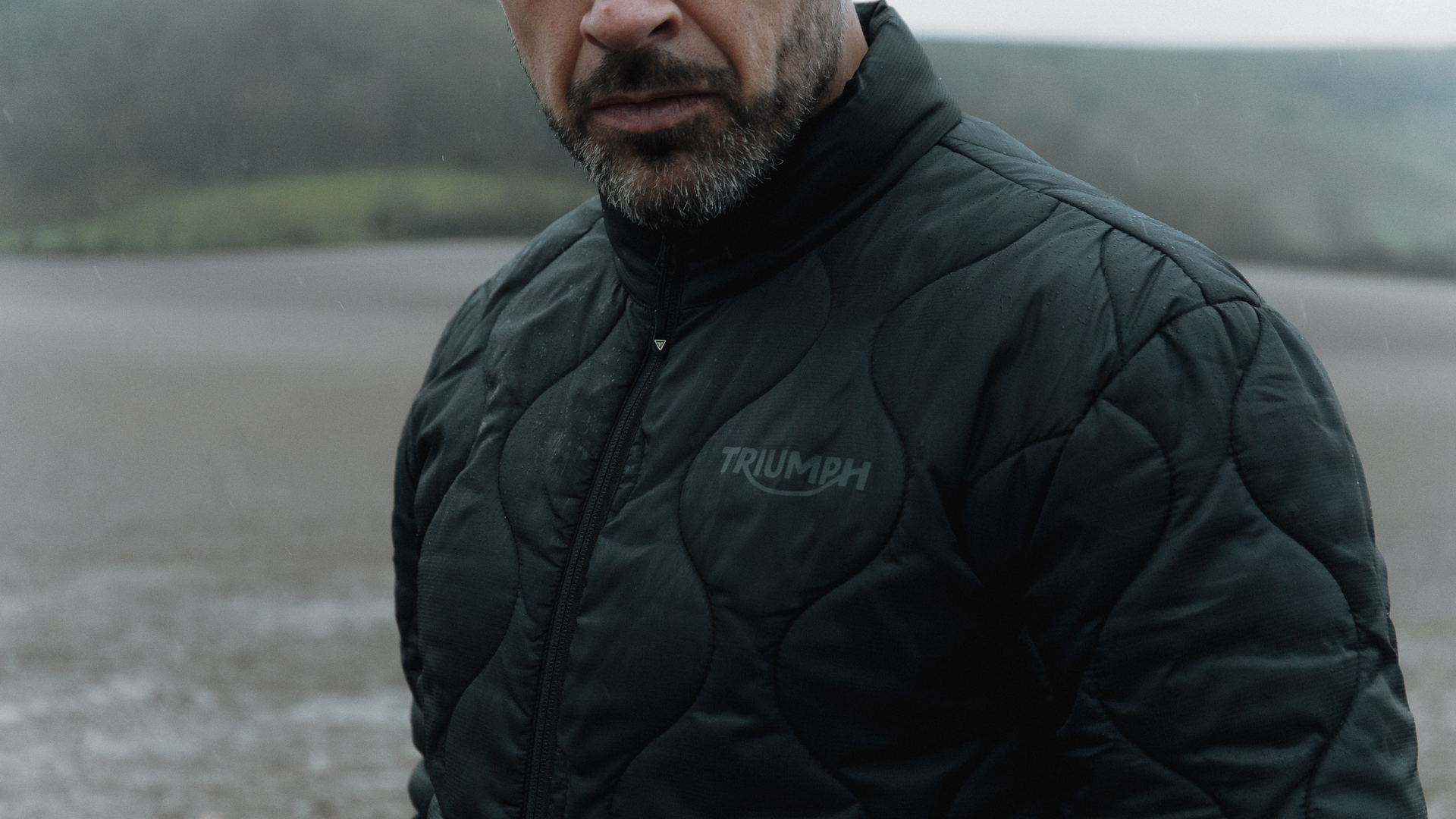 Man in the rain wearing PrimaLoft Jacket